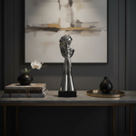 Silver praying sculpture close-up in luxury setting